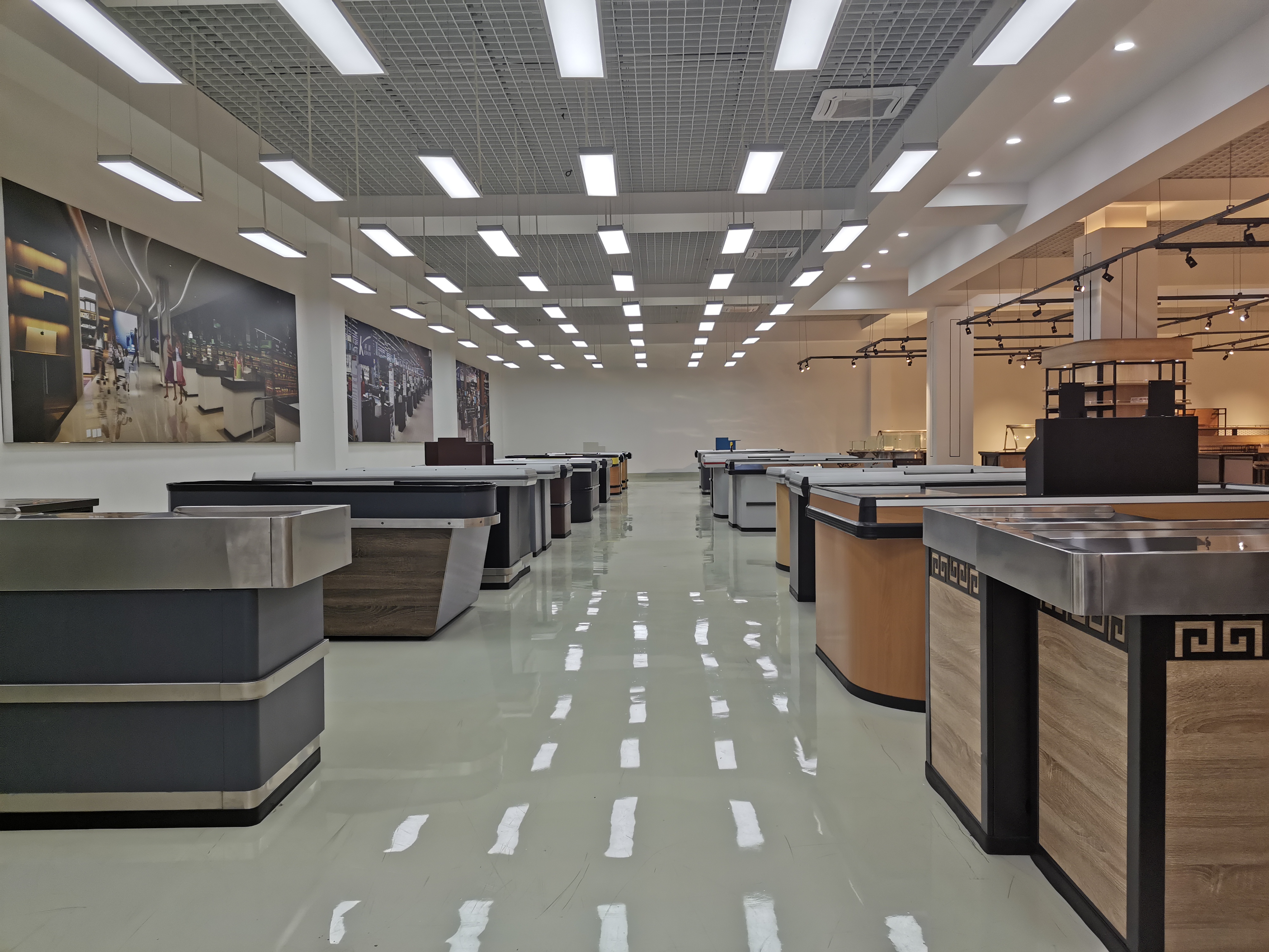 Red Keshun supermarket checkout counter with a conveyor belt and open packing shelf installed on a store floor