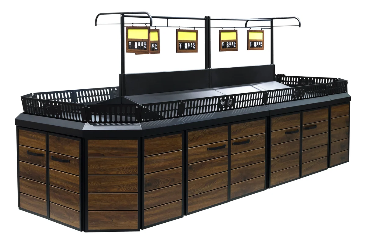 Black slatted supermarket produce island with wire crate rails along the top and overhead signs