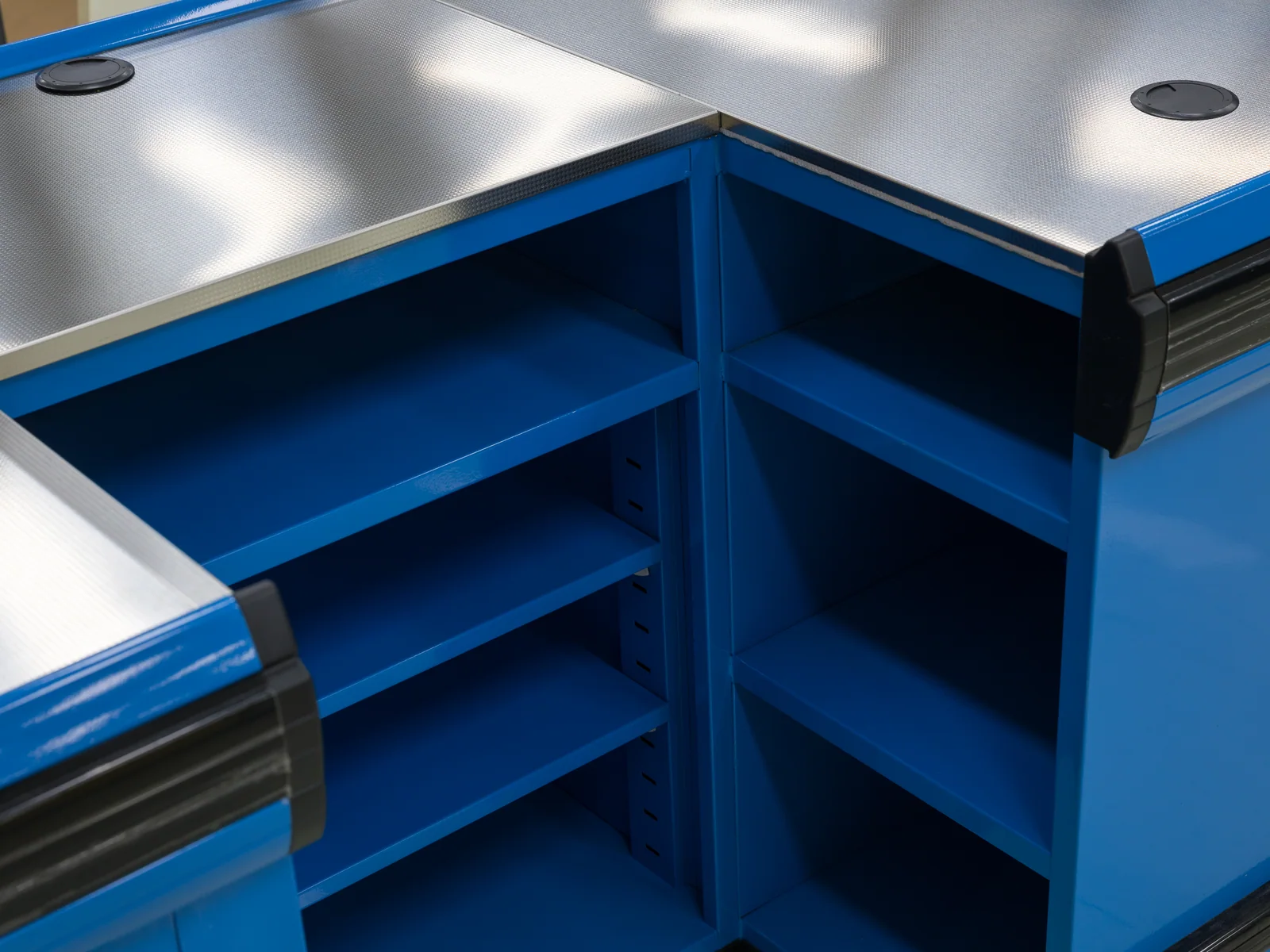 Boutique checkout counter in blue photographed from the corner, showing the sliding base doors