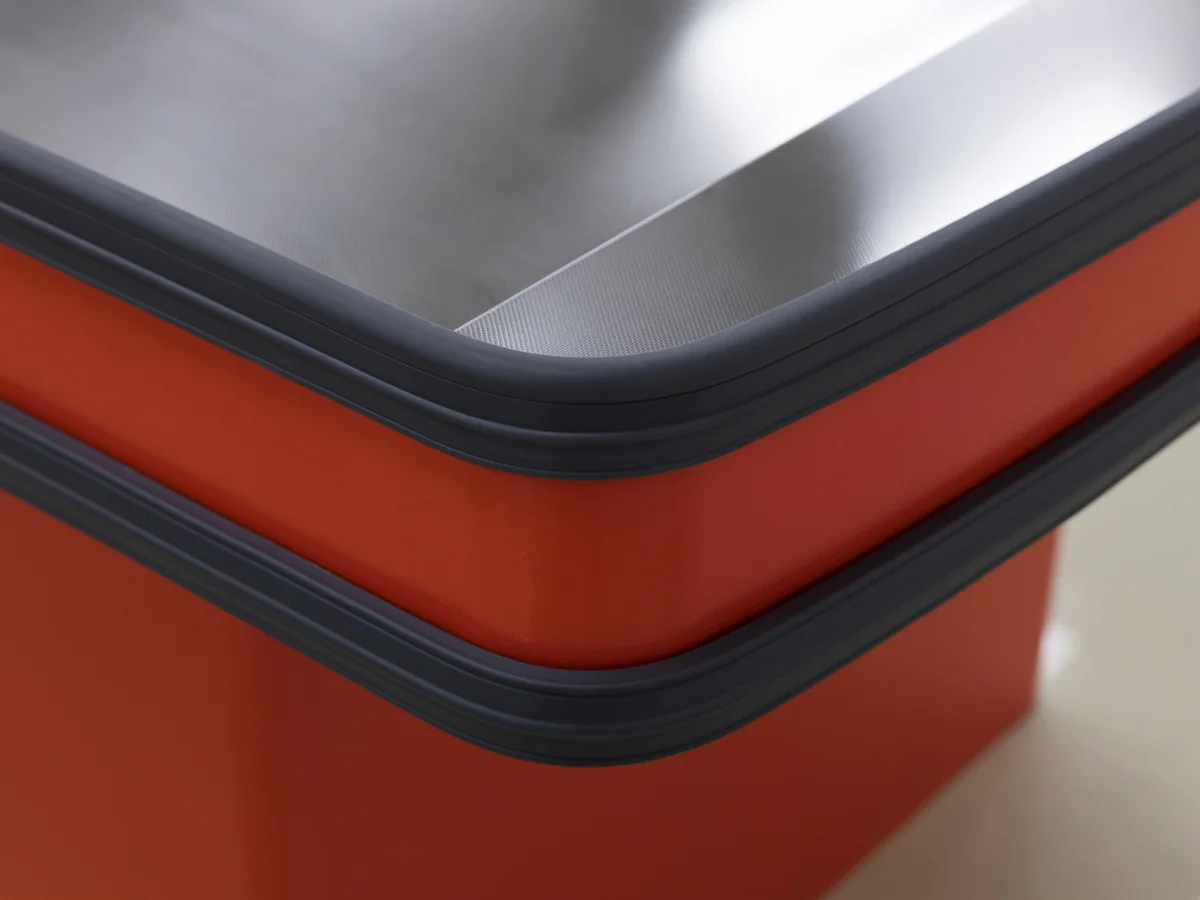 Close-up of the dark plinth and rail against the red body panel