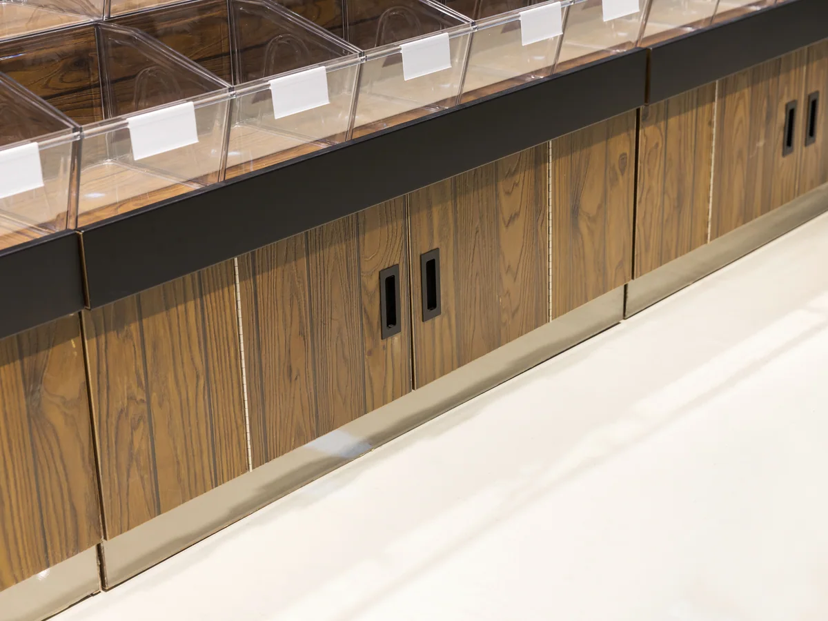 Close-up of the dark timber cabinet doors with a recessed handle at the base of the pyramid