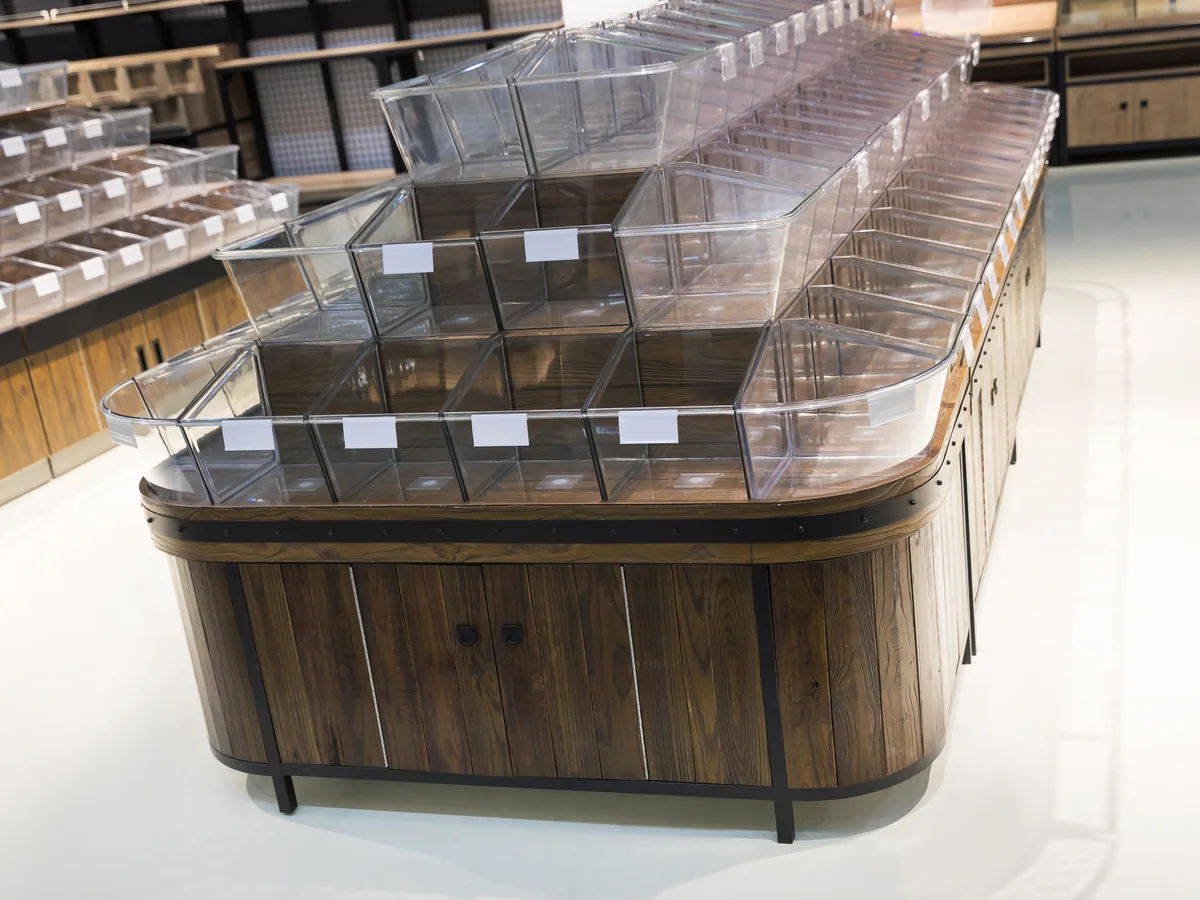 Close-up of the three stepped rows of clear tilt bins with ticket holders along the front lip