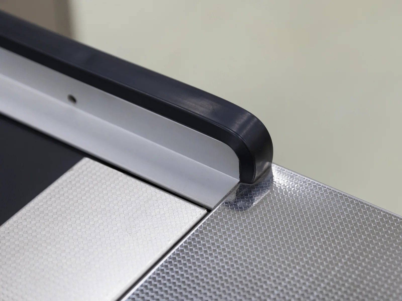 Close view of the stainless deck and border on a Keshun cashier counter with a drawer unit
