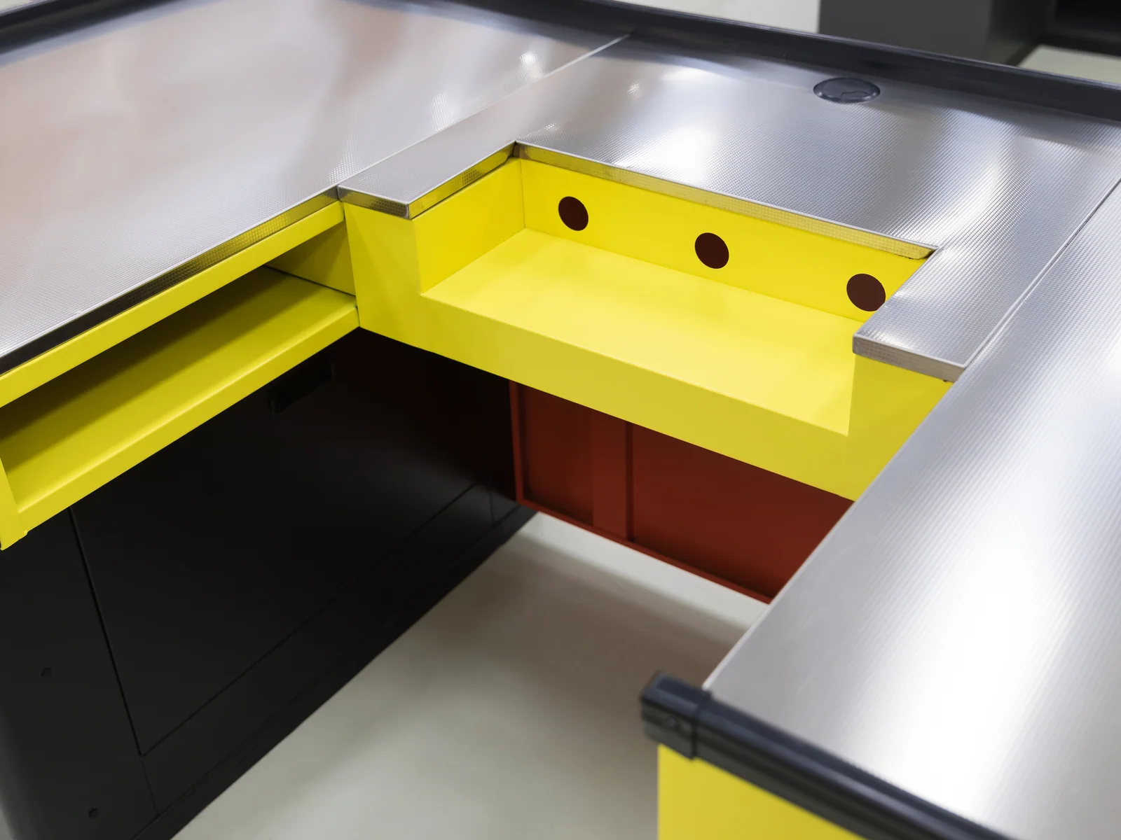 Two colour retail checkout counter photographed from the front, showing the rail and panel colours