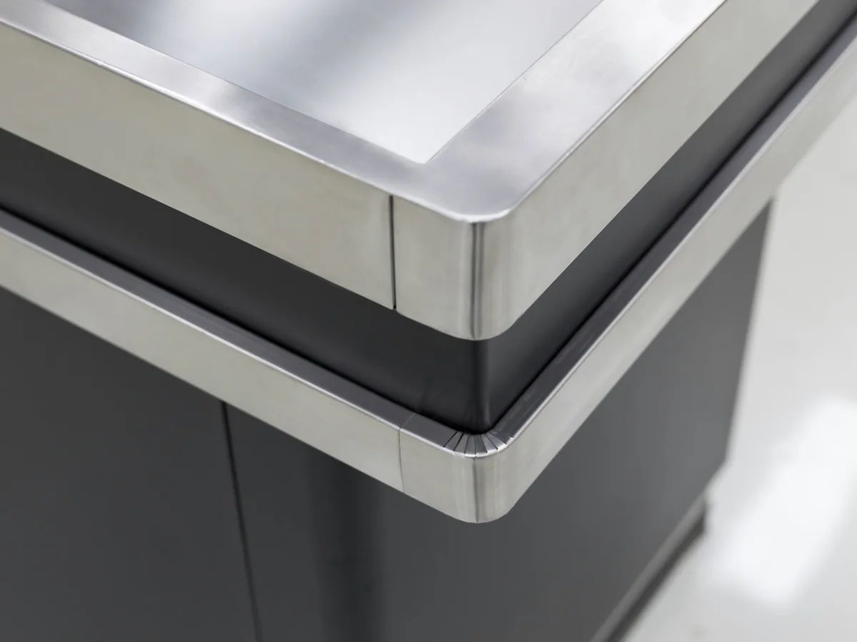 Dark powder coated steel cabinet panel with the kick plate on a Keshun cashier counter
