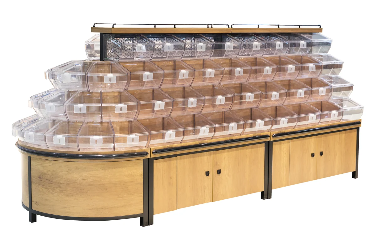 Long supermarket bulk food run with tiered clear tilt bins and a curved head end