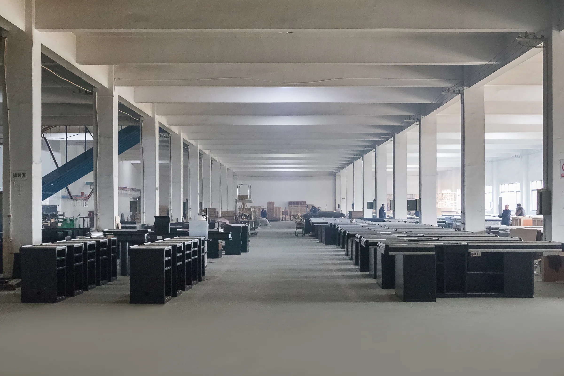 Long workshop aisle used for supermarket layout design planning, with finished checkout counters staged in rows