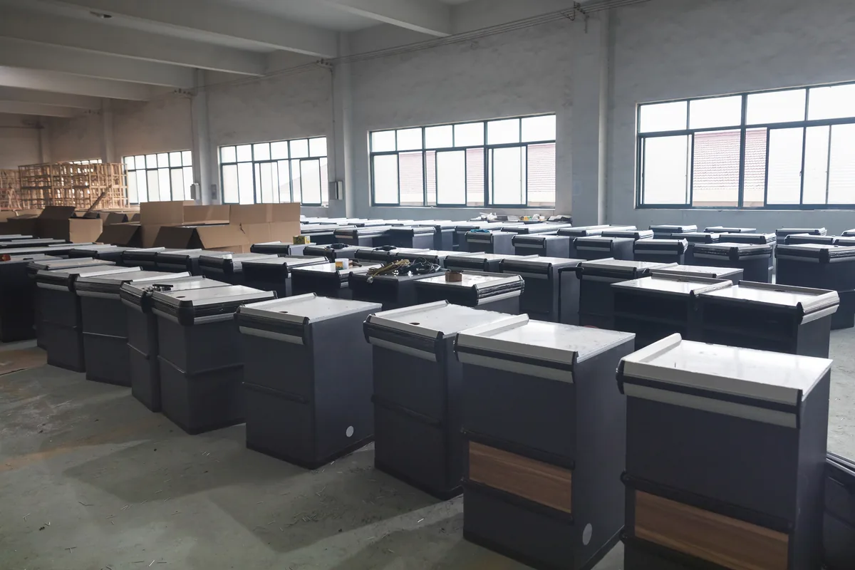Rows of finished supermarket checkout counters from one production batch staged in the Keshun workshop at Changshu