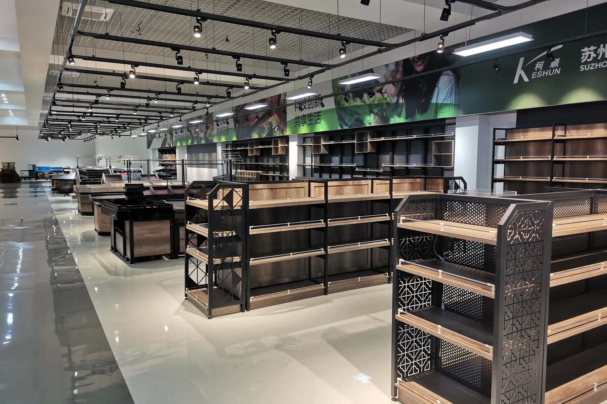 Showroom aisle of store fixtures with steel and wood shelving bays, produce islands and checkout counters